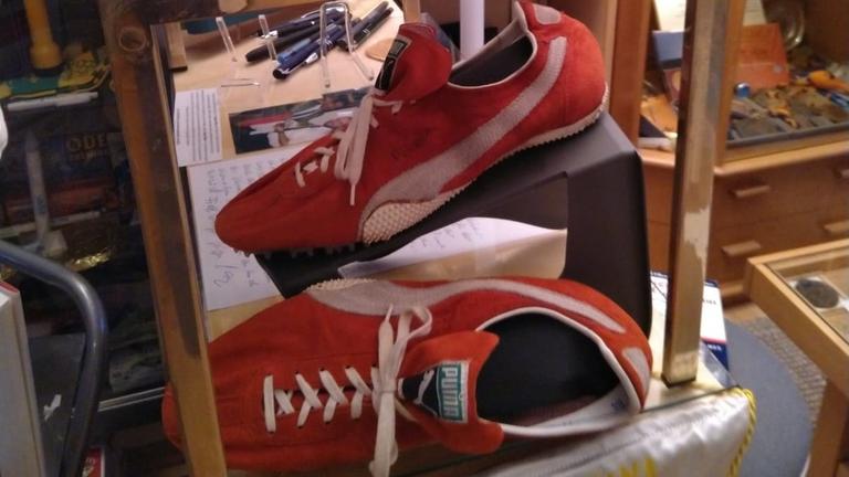 Rote Laufschuhe des Ausrüsters Puma in einem Sportmuseum neben vielen weiteren Exponaten Rote Laufschuhe des Ausrüsters Puma in einem Sportmuseum neben vielen weiteren Exponaten