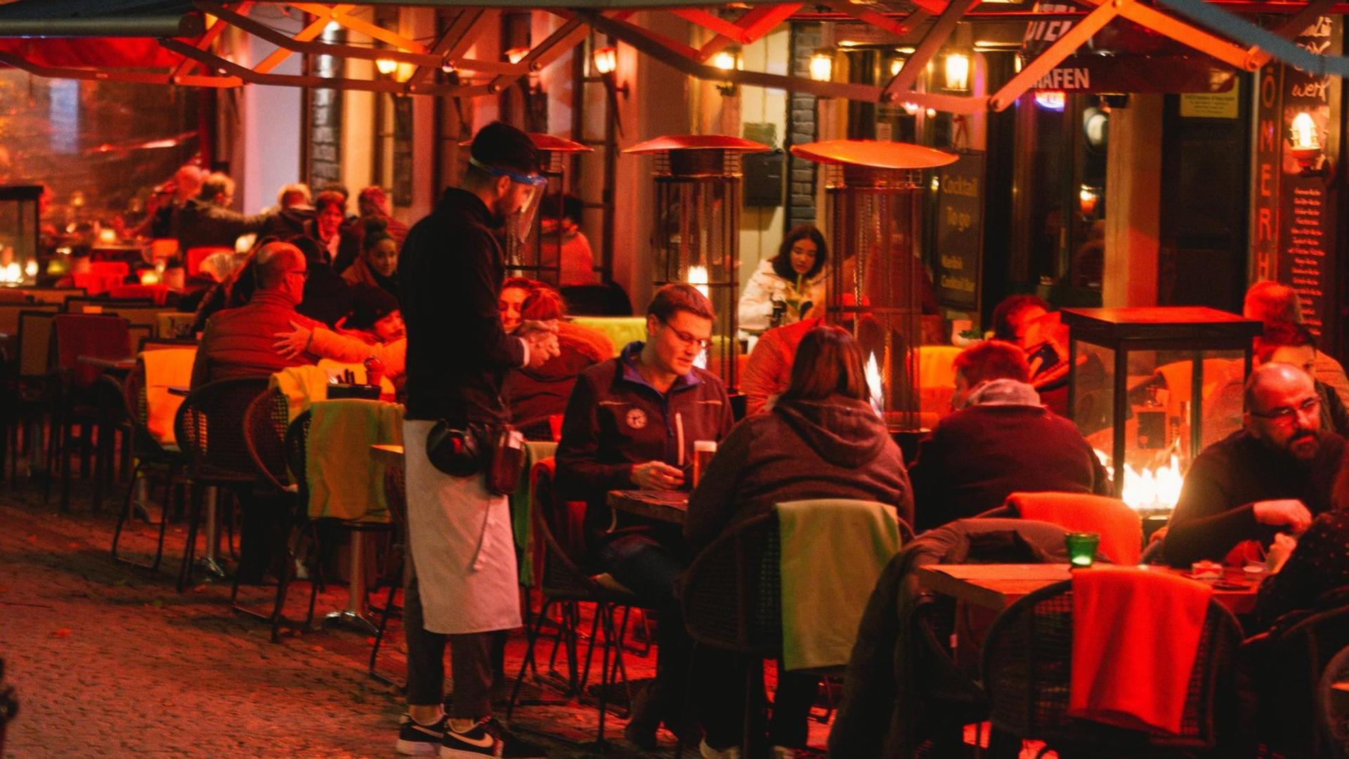 Restaurant voller Gäste im Freien, Köln. Restaurant voller Gäste im Freien, Köln.