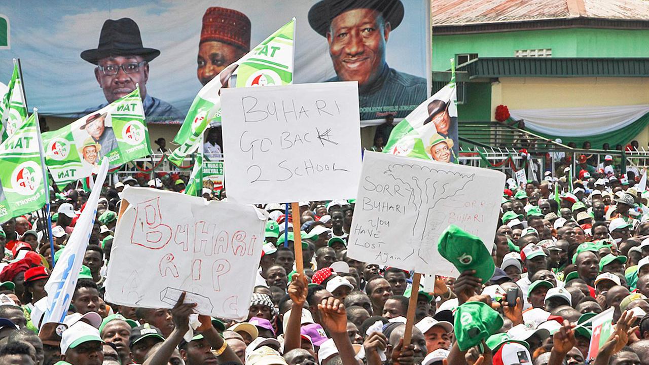 Eine Menschenmenge mit Plakaten, im Hintergrund eine große Werbung für Präsident Goodluck Jonathan. Eine Menschenmenge mit Plakaten, im Hintergrund eine große Werbung für Präsident Goodluck Jonathan.