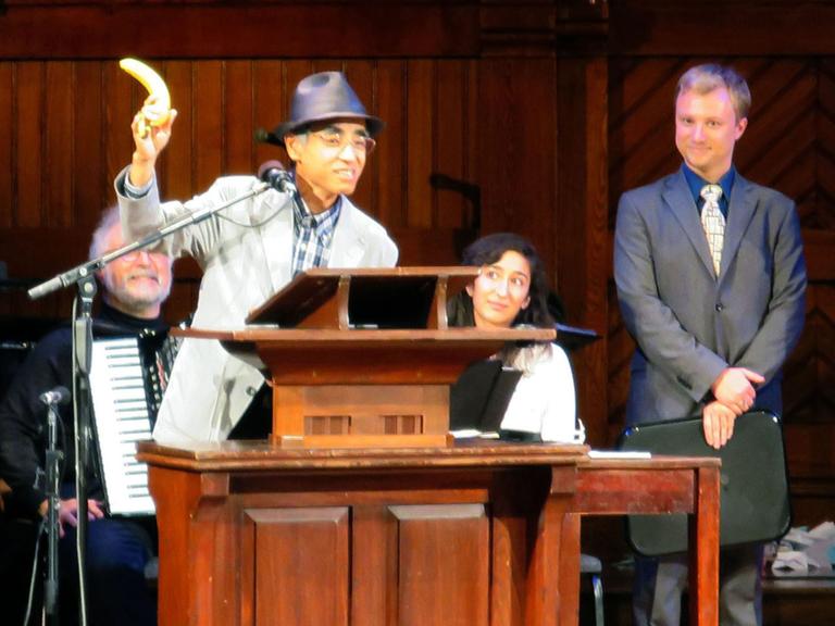Kiyoshi Mabuchi, Kitasato University, hält eine Banane zur Demonstration seines Forschungsobjektes hoch. Er referierte auf der Verleihungszeremonie der Ig-Nobel-Preise 2014 im Sanders Theater in Cambridge, Massachusetts.
