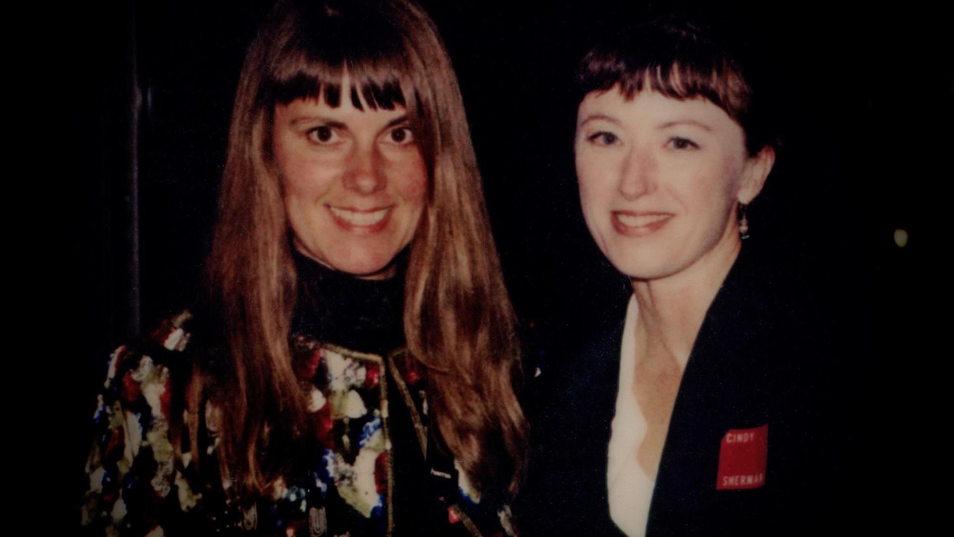 Gundula Schulze Eldowy und Cindy Sherman schauen lächelnd in die Kamera. Gundula Schulze Eldowy und Cindy Sherman schauen lächelnd in die Kamera.