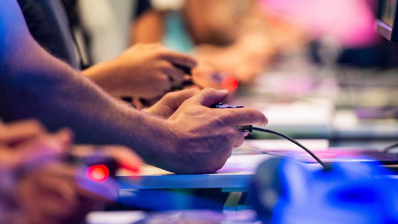 Besucher der Gamescom 2018 probieren an einem Stand von EA Sports das Videospiel Fifa 19 aus. Besucher der Gamescom 2018 probieren an einem Stand von EA Sports das Videospiel Fifa 19 aus.