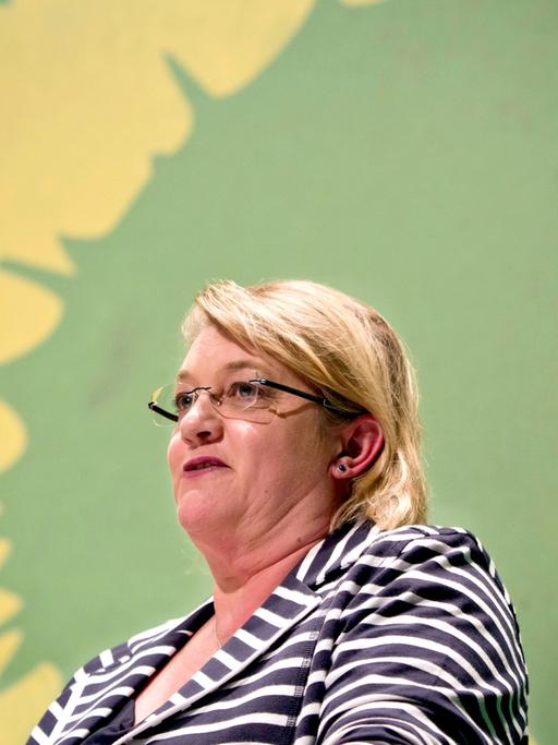 Die Grünen-Politikerin Kordula Schulz-Asche vor dem Sonnenblumen-Logo ihrer Partei