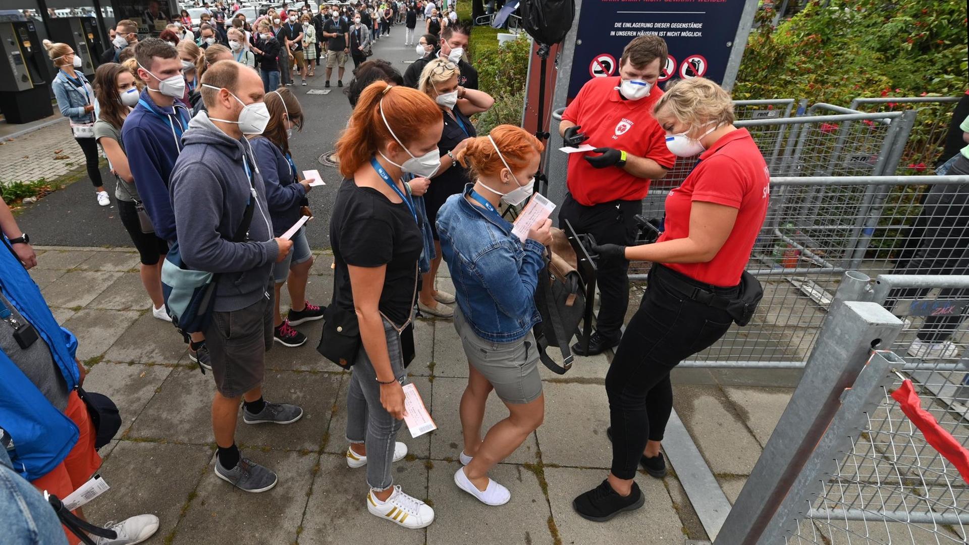 Probanden eines Großversuchs der Universitätsmedizin Halle/Saale stehen am Einlass vor der Arena Leipzig. Rund 1400 Besucher beteiligen sich an dem Versuch unter dem Titel «Restart-19», bei dem der Popsänger Tim Bendzko auftritt. Probanden eines Großversuchs der Universitätsmedizin Halle/Saale stehen am Einlass vor der Arena Leipzig. Rund 1400 Besucher beteiligen sich an dem Versuch unter dem Titel «Restart-19», bei dem der Popsänger Tim Bendzko auftritt.
