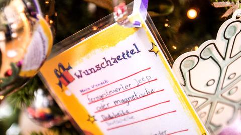 Ein Wunschzettel hängt am 23.11.2015 in Frankfurt am Main (Hessen) an einem Weihnachtsbaum. Rund 4000 Weihnachtswünsche, die bedürftige Kinder an fast 80 Weihnachtsbäumen in Frankfurt am Main anbringen dürfen, können dieses Jahr erfüllt werden.