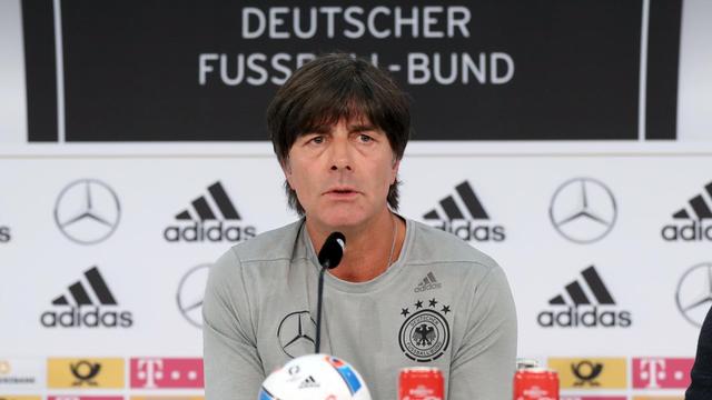 Löw sitz vor einer Wand mit den Sponsoren-Logos der Nationalmannschaft und der Aufschrift "Deutscher Fußball-Bund" und spricht in ein Mikrofon. Vor ihm liegt ein Fußball auf dem Tisch.