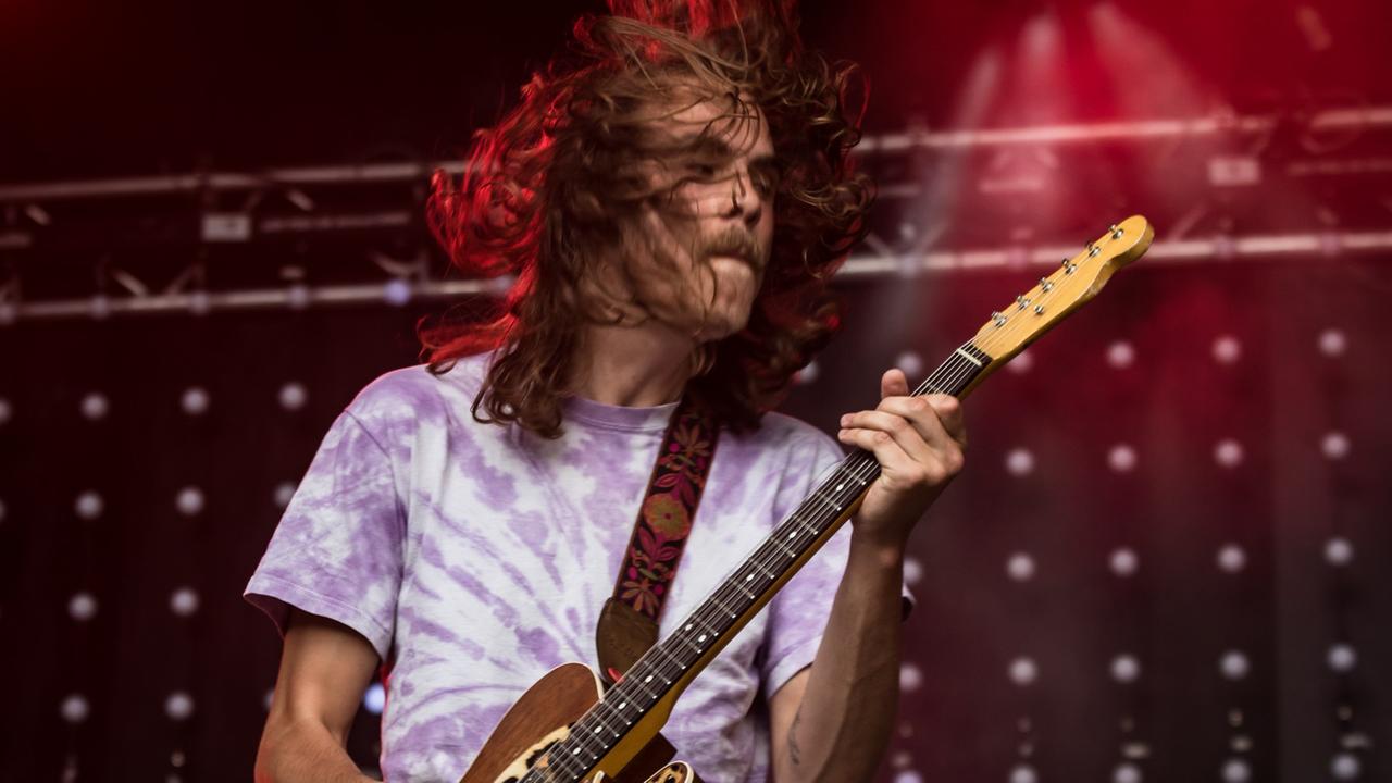 Mann steht auf einer Bühne und spielt Gitarre. Mann steht auf einer Bühne und spielt Gitarre.