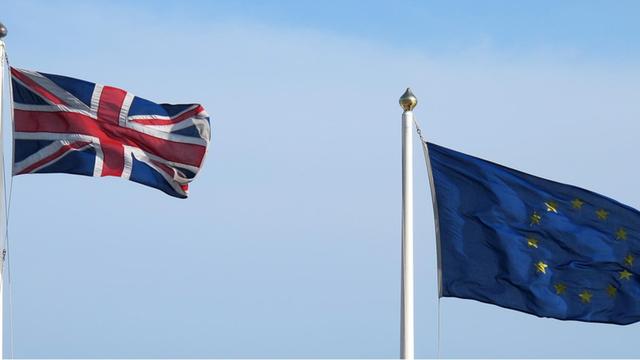 Die Fahne Großbritanniens und eine "ausgefranste" Europa-Fahne wehen nebeneinander im Hafen von Dover (GB), aufgenommen am 28.05.2016