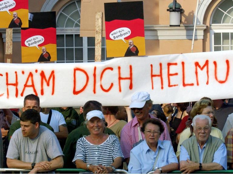 Weimar (Thüringen): Ein Spruchband mit der Aufschrift "Schäm Dich Helmut" halten am 20.08.2002 Gegendemonstranten bei einer Wahlkampfveranstaltung der CDU mit Altbundeskanzler Helmut Kohl auf dem Theaterplatz in Weimar.
