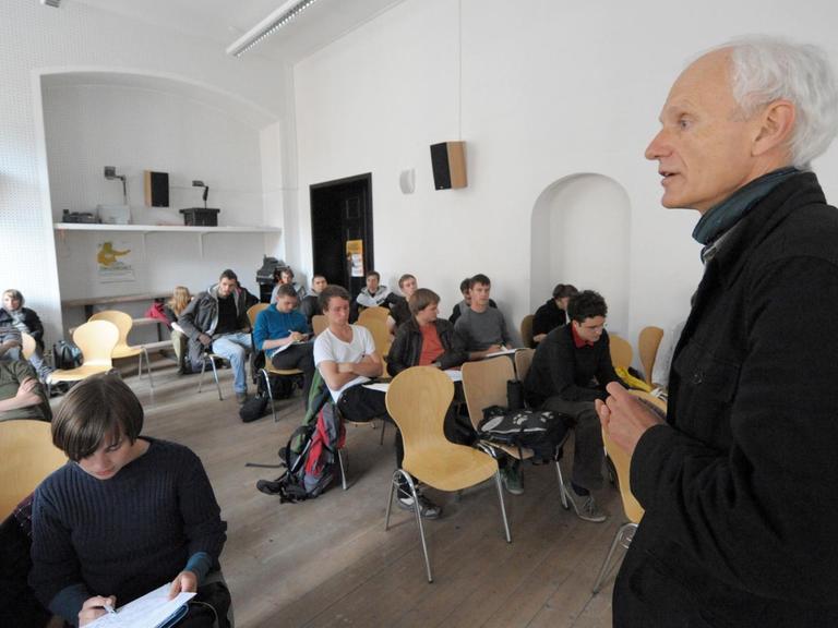 Christoph Türcke spricht in einem Seminarraum vor Studierenden.