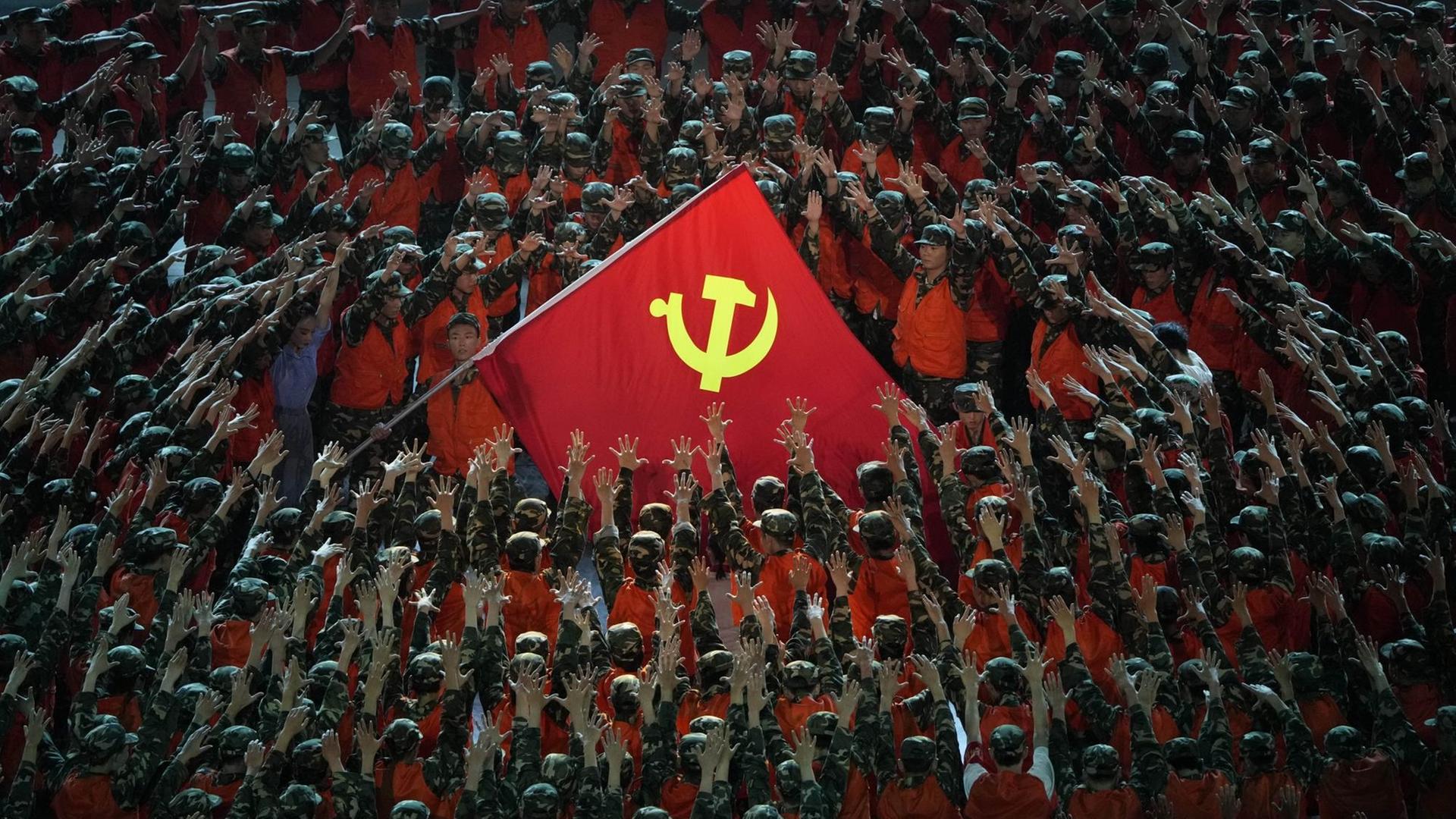 Als Rettungskräfte verkleidete Darsteller versammeln sich um eine Fahne der Kommunistischen Partei während einer Gala-Show im Vorfeld des hundertjährigen Jubiläums der Gründung der Kommunistischen Partei Chinas. Als Rettungskräfte verkleidete Darsteller versammeln sich um eine Fahne der Kommunistischen Partei während einer Gala-Show im Vorfeld des hundertjährigen Jubiläums der Gründung der Kommunistischen Partei Chinas.