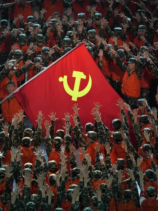 Als Rettungskräfte verkleidete Darsteller versammeln sich um eine Fahne der Kommunistischen Partei während einer Gala-Show im Vorfeld des hundertjährigen Jubiläums der Gründung der Kommunistischen Partei Chinas.