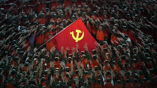 Als Rettungskräfte verkleidete Darsteller versammeln sich um eine Fahne der Kommunistischen Partei während einer Gala-Show im Vorfeld des hundertjährigen Jubiläums der Gründung der Kommunistischen Partei Chinas.