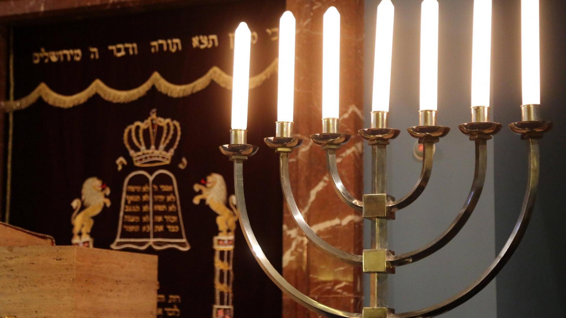 Eine Menorah steht vor dem mit einem Vorhang verdeckten Ahron haKodesch, dem Aufbewahrungsort für die Thorarollen, in der Erfurter Synagoge Eine Menorah steht vor dem mit einem Vorhang verdeckten Ahron haKodesch, dem Aufbewahrungsort für die Thorarollen, in der Erfurter Synagoge