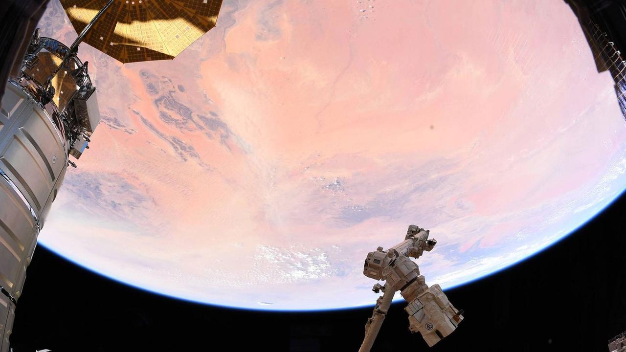 Ein Blick aus der Internationalen Raumstation ISS auf einen Teil der Erde, die von der Sonne rosa gefärbt ist Ein Blick aus der Internationalen Raumstation ISS auf einen Teil der Erde, die von der Sonne rosa gefärbt ist