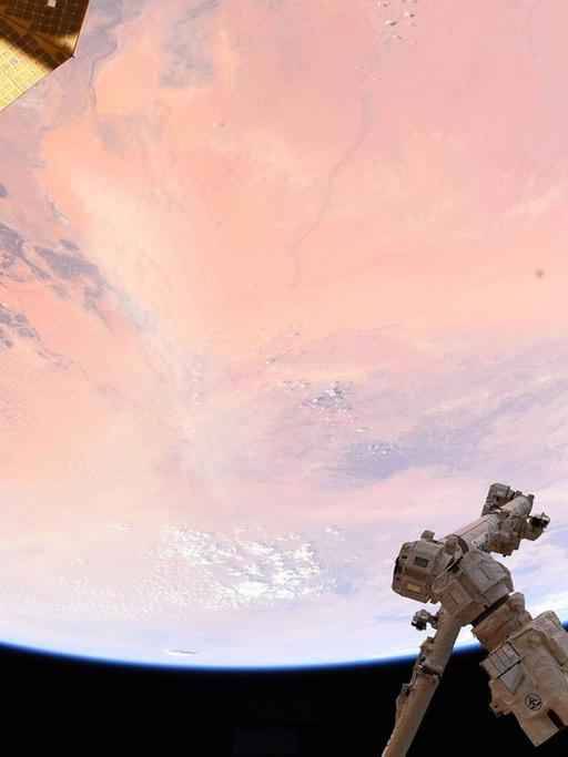 Ein Blick aus der Internationalen Raumstation ISS auf einen Teil der Erde, die von der Sonne rosa gefärbt ist