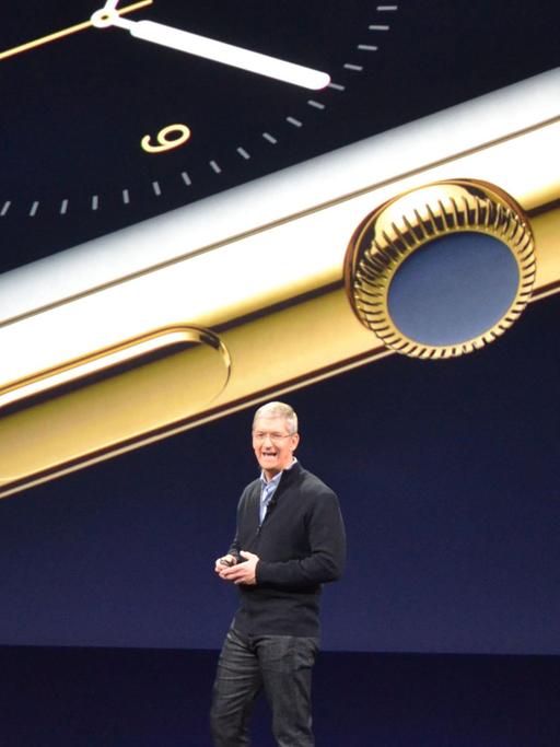 Tim Cook steht auf einer Bühne, im Hintergrund eine große Uhr auf einem Bildschirm zu sehen.