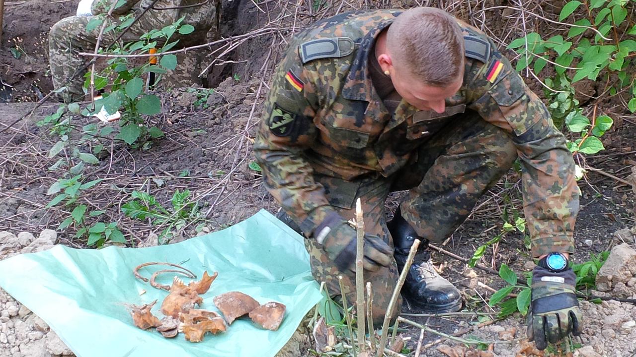Bundeswehrsoldat sichert sterbliche Überreste eines Wehrmachtssoldaten auf dem Askoldowa-Mogila-Friedhof in Kiew. Bundeswehrsoldat sichert sterbliche Überreste eines Wehrmachtssoldaten auf dem Askoldowa-Mogila-Friedhof in Kiew.