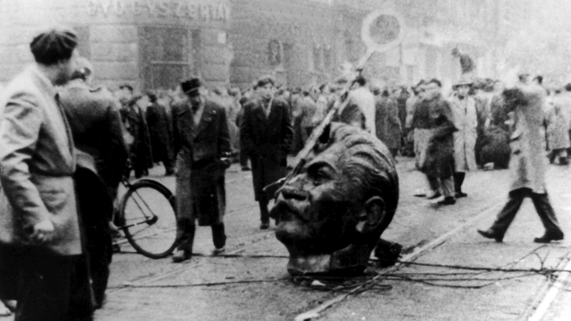 Der Kopf eines gestürzten Stalin-Denkmals auf der Straße. Am 23. Oktober 1956 fielen bei einer zunächst friedlichen Kundgebung in Budapest erste Schüsse. Arbeiter, Studenten und Jugendliche bewaffneten sich und nahmen den Kampf gegen die einrückenden sowjetischen Truppen auf. Der Kopf eines gestürzten Stalin-Denkmals auf der Straße. Am 23. Oktober 1956 fielen bei einer zunächst friedlichen Kundgebung in Budapest erste Schüsse. Arbeiter, Studenten und Jugendliche bewaffneten sich und nahmen den Kampf gegen die einrückenden sowjetischen Truppen auf.