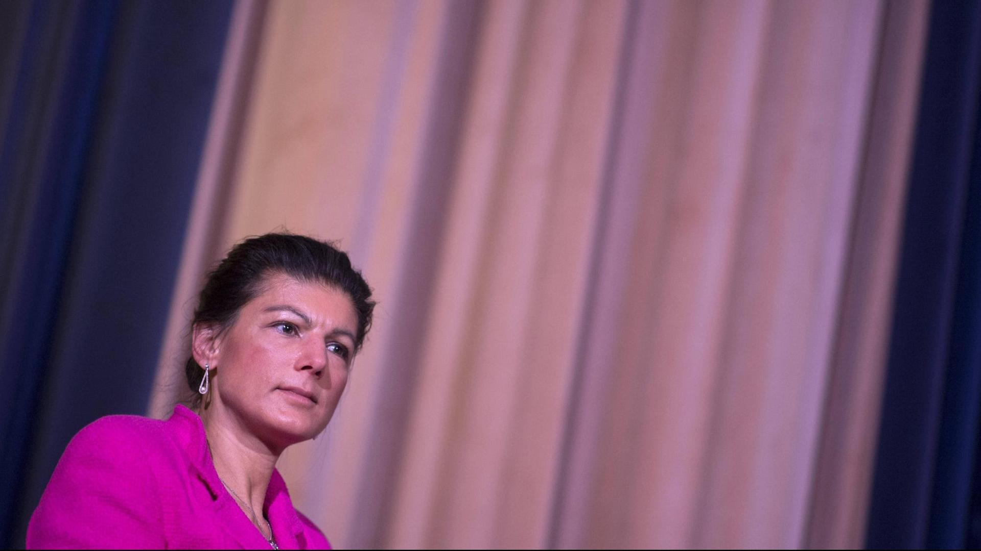 Porträt von Sahra Wagenknecht in lilafarbener Jacke vor einem blassvioletten Kinovorhang. Porträt von Sahra Wagenknecht in lilafarbener Jacke vor einem blassvioletten Kinovorhang.