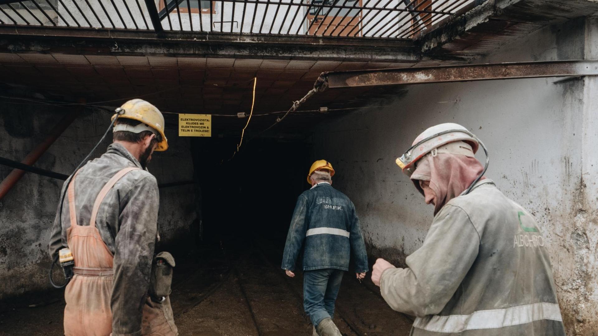 Drei Männer gehen in einen Bergbauschacht. Drei Männer gehen in einen Bergbauschacht.