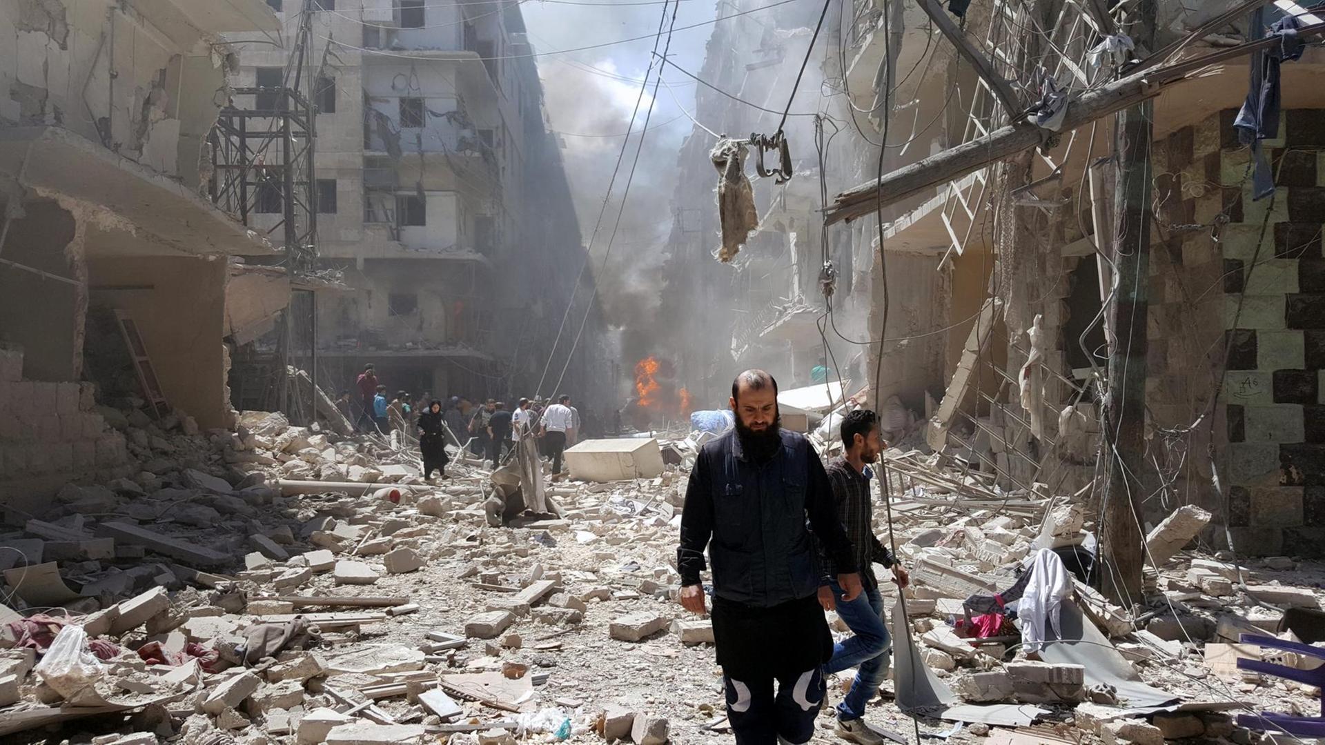 Der von Aufständischen kontrollierte Ostteil Aleppos wird durch Angriffe der syrischen Luftwaffe erschüttert. Sie sehen Syrer, die inmitten von Trümmern laufen. Der von Aufständischen kontrollierte Ostteil Aleppos wird durch Angriffe der syrischen Luftwaffe erschüttert. Sie sehen Syrer, die inmitten von Trümmern laufen.