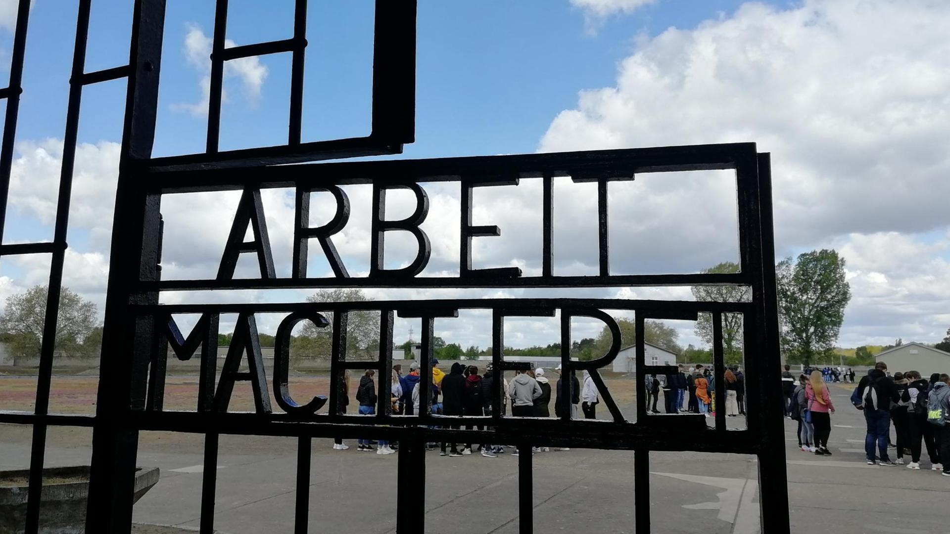Das Bild zeigt ein Tor im ehemaligen KZ Sachsenhausen, das den Spruch "Arbeit macht frei" trägt. Das Bild zeigt ein Tor im ehemaligen KZ Sachsenhausen, das den Spruch "Arbeit macht frei" trägt.