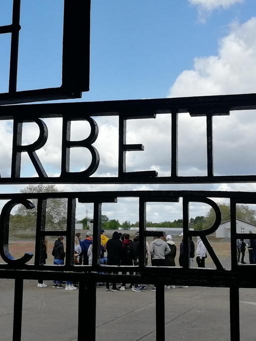Das Bild zeigt ein Tor im ehemaligen KZ Sachsenhausen, das den Spruch "Arbeit macht frei" trägt.