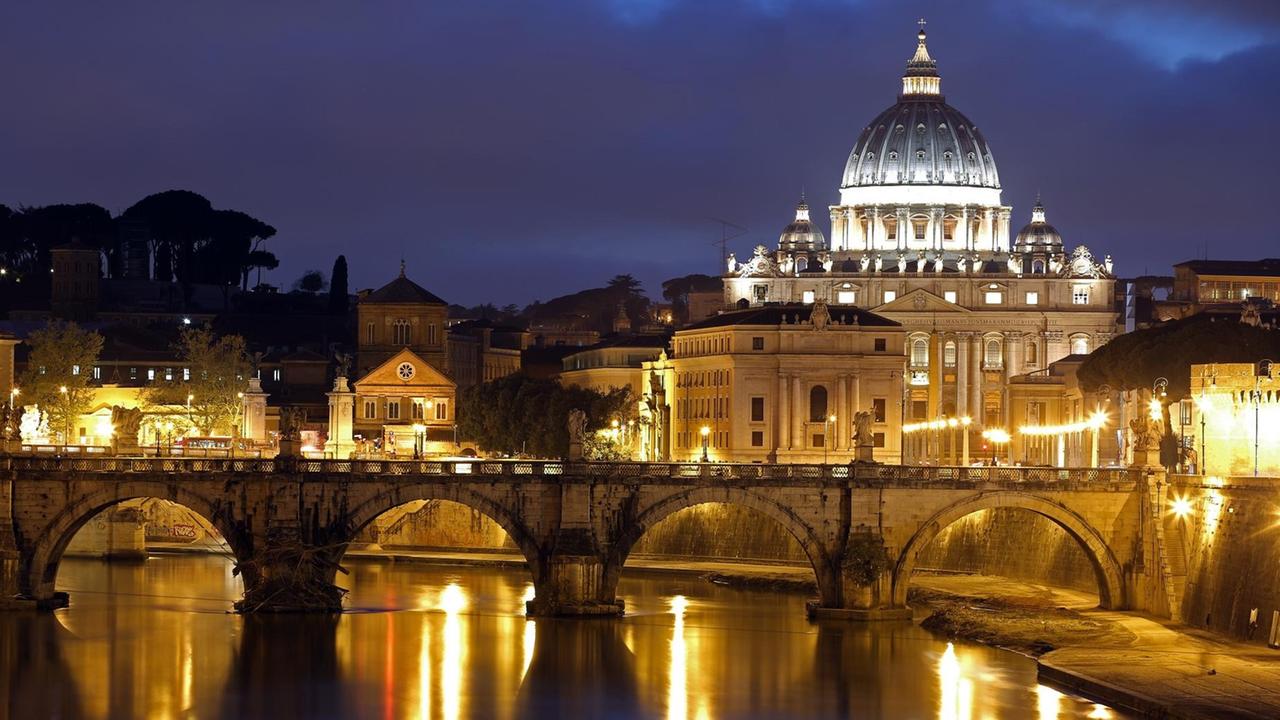 Der Petersdom im Vatikan vor dem abendlichen Himmel. Vorne verläuft die Engelsbrücke über den Tiber. Der Petersdom im Vatikan vor dem abendlichen Himmel. Vorne verläuft die Engelsbrücke über den Tiber.