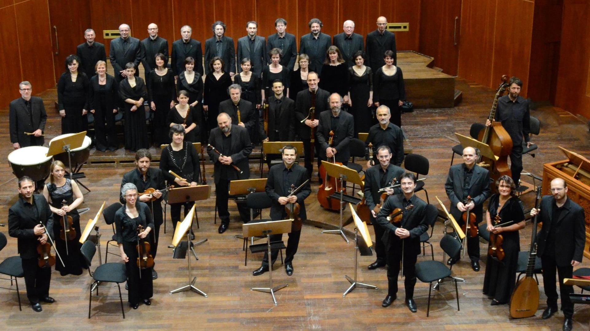 Das Ensemble I Barocchisti, mit Streichern, Bläsern, Schlagwerk und Orgel, wurde beim Konzert in Lugano vom Lautenisten Luca Pianca geleitet. Der Coro della Radiotelevisione Svizzera ist hinter dem Orchester positioniert. Chor und Orchester stehen in Konzertkleidung auf der Bühne und schauen in die Kamera Das Ensemble I Barocchisti, mit Streichern, Bläsern, Schlagwerk und Orgel, wurde beim Konzert in Lugano vom Lautenisten Luca Pianca geleitet. Der Coro della Radiotelevisione Svizzera ist hinter dem Orchester positioniert. Chor und Orchester stehen in Konzertkleidung auf der Bühne und schauen in die Kamera