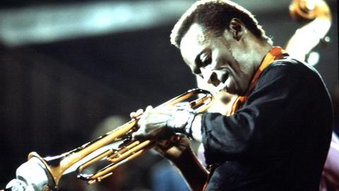 Der amerikanische Jazzmusiker Miles Davis (1926−1991) spielt Trompete auf einem undatierten Konzertfoto.