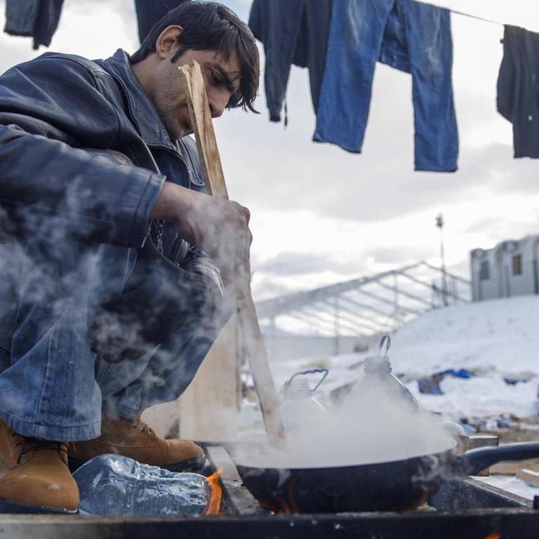 Hard winter in the Lipa migrant camp January 15, 2021, Bihac, Bosnia and Herzegovina - Migrants cook at the Lipa migrant camp, located a few kilometers from Bihac, still does not meet the basic requirements for a normal stay. Military tents have been set up to soak, there is no running water, and it freezes in bottles and canisters because temperatures reach -15 degrees Celsius. They bathe in nearby streams that also serve to wash clothes or melt snow to get water. Most migrants do not want to stay here because, as they say, this is not a life worthy of a human being. In order to get to Bihac where they can buy something or take the money they send them, they need to walk for 6 or more hours in one direction only. Many are sick and in pain ArminxDurgut/PIXSELL