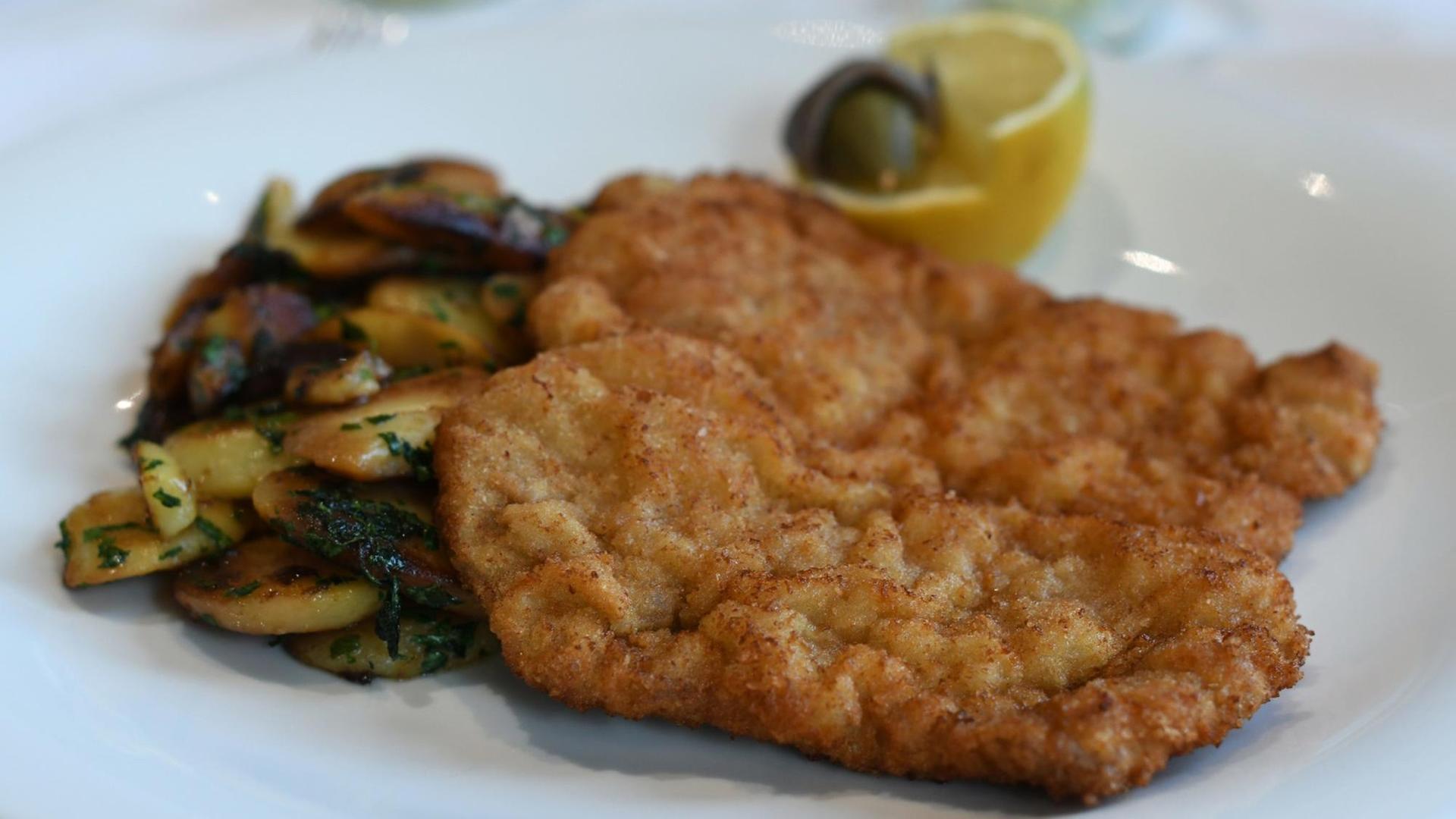 Küchenklassiker, Wiener Schnitzel aus der Kalbsnuss, mit welliger Panade, serviert in einem Restaurant in Dortmund. Küchenklassiker, Wiener Schnitzel aus der Kalbsnuss, mit welliger Panade, serviert in einem Restaurant in Dortmund.