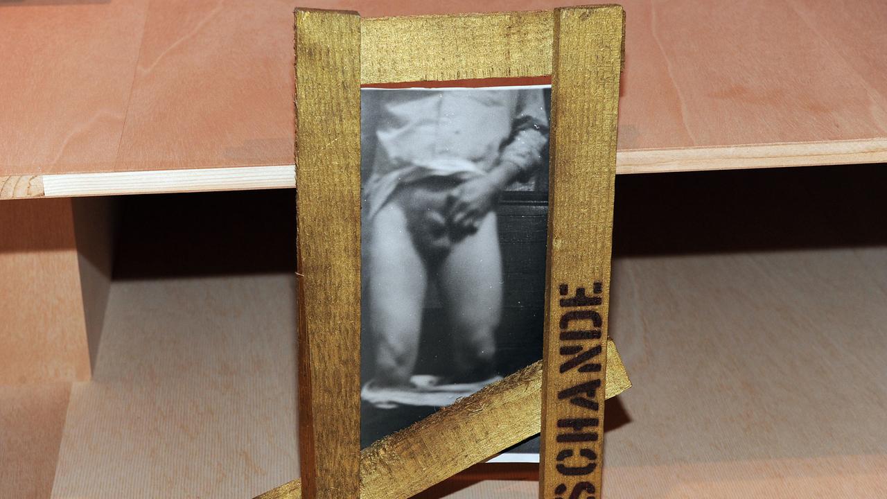 "Schande" von 1986: Schwarz-weiß-Fotografie mit Dachlatten in Gold "Schande" von 1986: Schwarz-weiß-Fotografie mit Dachlatten in Gold