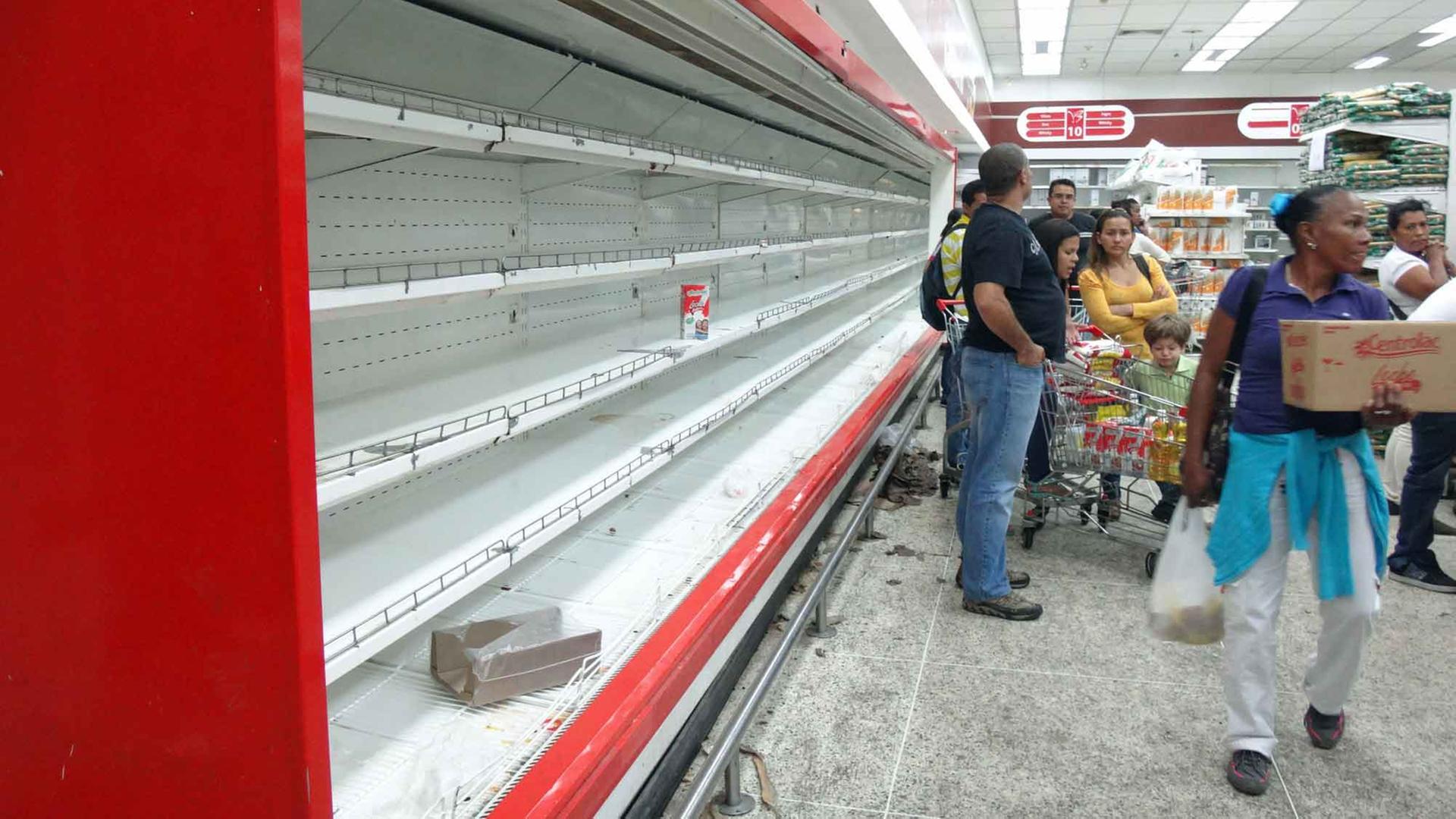 Kunden stehen im Supermarkt in Caracas, Venezuela, vor leeren Regalen. Kunden stehen im Supermarkt in Caracas, Venezuela, vor leeren Regalen.