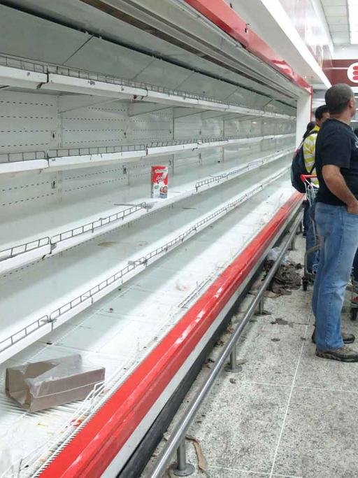 Kunden stehen im Supermarkt in Caracas, Venezuela, vor leeren Regalen.