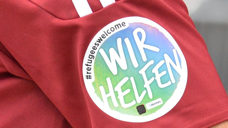 Der Aktions-Schriftzug «#refugeeswelcome WIR HELFEN» steht auf dem Trikot eines Nürnberger Spielers. Der Aktions-Schriftzug «#refugeeswelcome WIR HELFEN» steht auf dem Trikot eines Nürnberger Spielers.