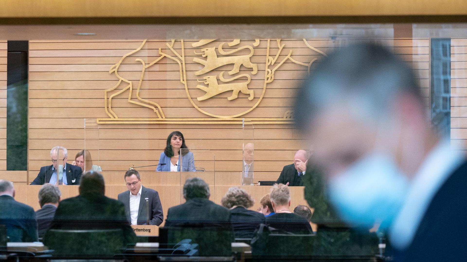 Ein Mann mit Mund-Nasen-Schutz geht während einer Plenarsitzung im Landtag von Baden-Württemberg am Plenarsaal vorbei. Ein Mann mit Mund-Nasen-Schutz geht während einer Plenarsitzung im Landtag von Baden-Württemberg am Plenarsaal vorbei.