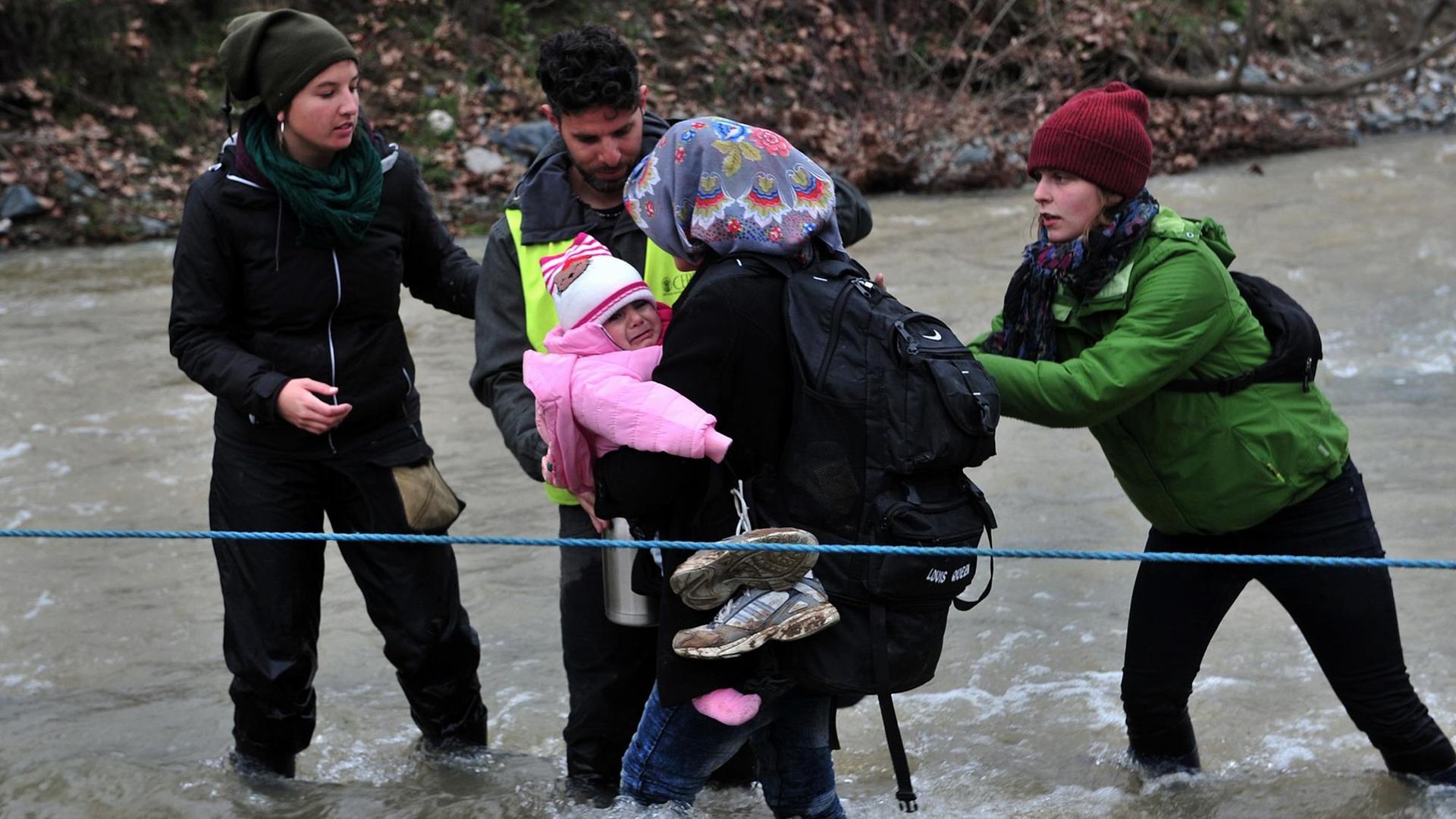 Flüchtlinge überqueren einen Fluss an der Grenze zwischen Griechenland und Mazedonien Flüchtlinge überqueren einen Fluss an der Grenze zwischen Griechenland und Mazedonien