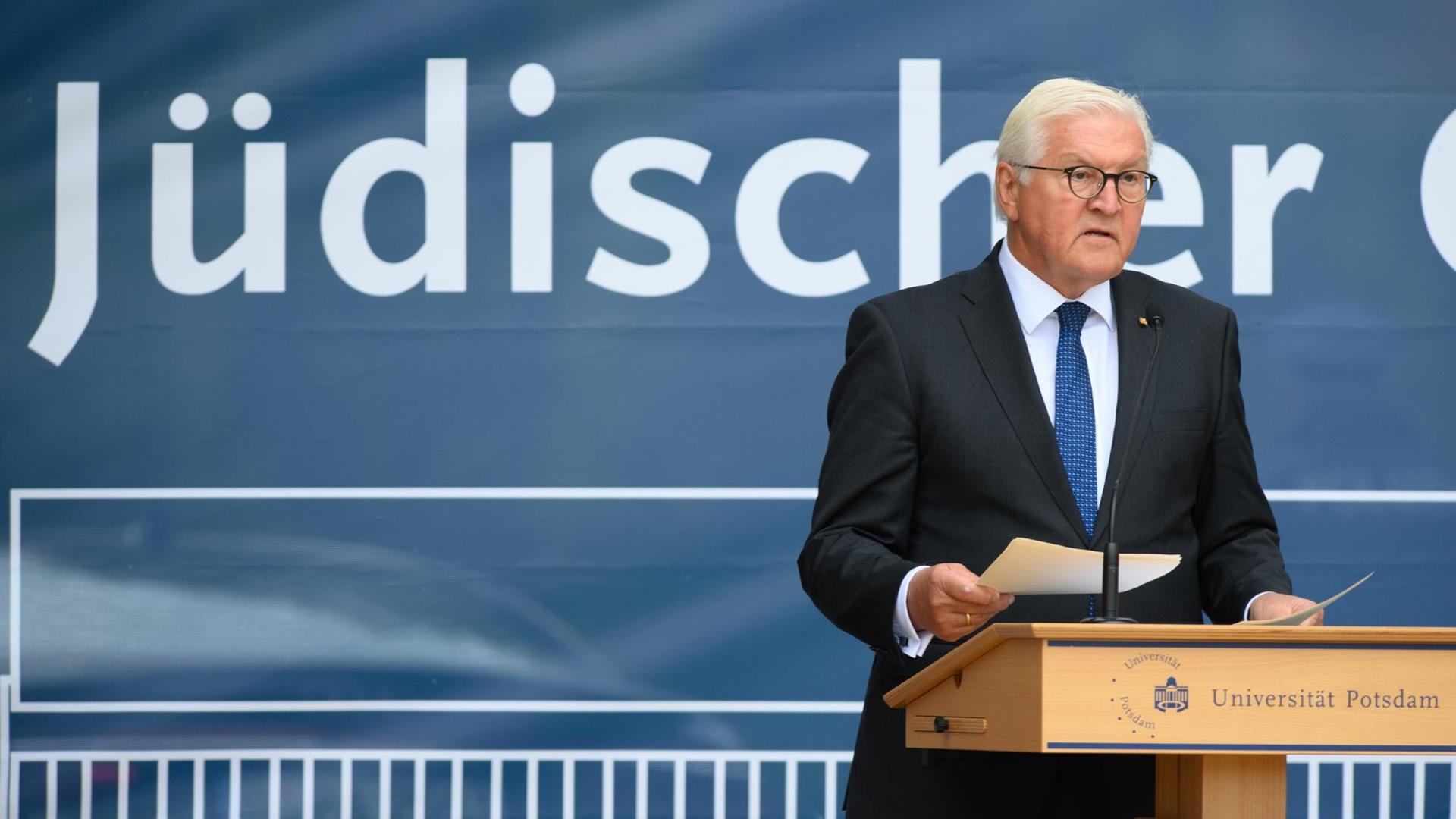 Bundes-Präsident Frank-Walter Steinmeier steht auf einer Bühne. Bundes-Präsident Frank-Walter Steinmeier steht auf einer Bühne.