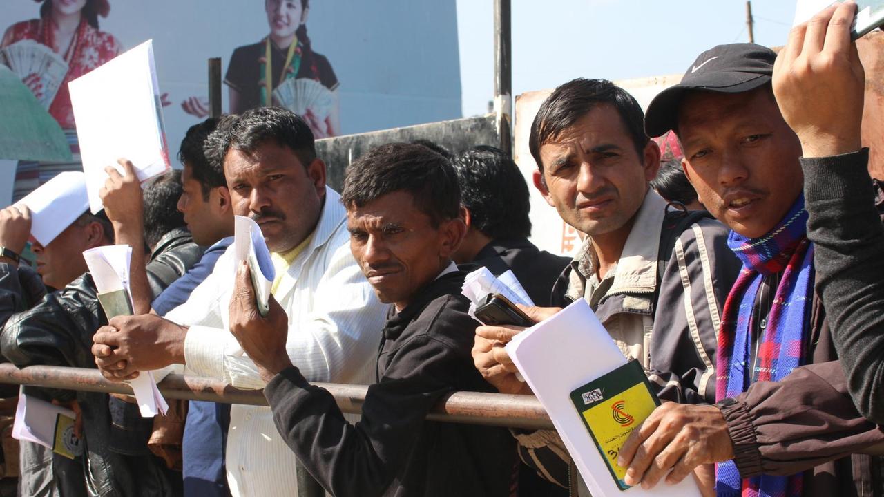 Männer warten vor dem "Department of Foreign Employment" in Kathmandu, Nepal, auf ihre Papiere zur Ausreise. Männer warten vor dem "Department of Foreign Employment" in Kathmandu, Nepal, auf ihre Papiere zur Ausreise.