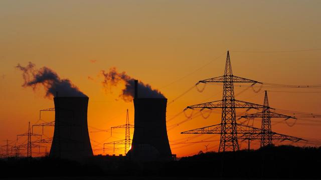 Atomkraftwerk Grafenrheinfeld, daneben Strommasten, vor Sonnenuntergang