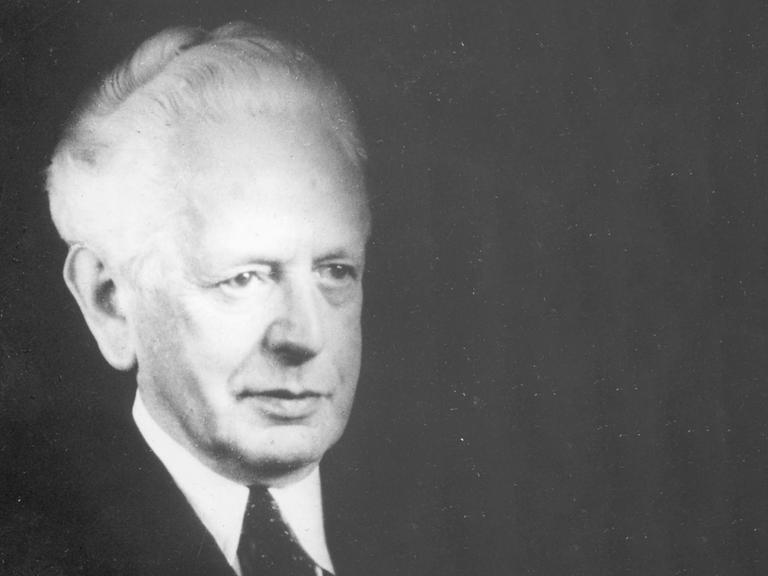 Porträt des Philosophen Ernst Cassierer vor schwarzem Hintergrund.