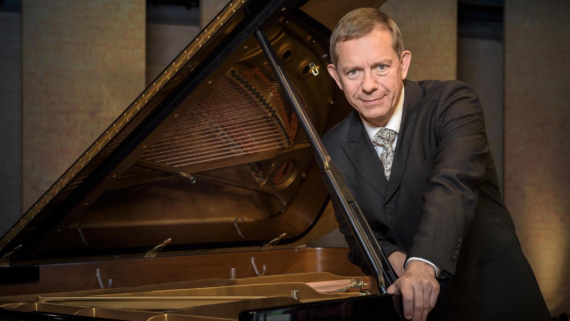 Der Pianist lehnt sich vorsichtig an den geöffneten Flügel. Der Pianist lehnt sich vorsichtig an den geöffneten Flügel.