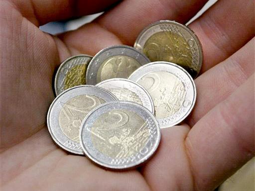 Zwei-Euro-Münzen liegen in einer Hand.