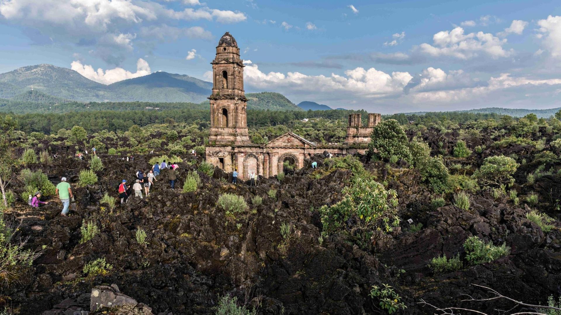 San Juan Parangaricutiro, Michoacan, Mexiko: Touristen klettern im erstarrten Lavagestein, das die Runinen der Kirche von San Juan Parangaricutiro umgibt. Die Kirche ist das einzige Bauwerk, das nach dem achtjährigen Ausbruch des Vulkans Paricutin, der 1943 zwei Dörfer verschlang, übrig blieb. San Juan Parangaricutiro, Michoacan, Mexiko: Touristen klettern im erstarrten Lavagestein, das die Runinen der Kirche von San Juan Parangaricutiro umgibt. Die Kirche ist das einzige Bauwerk, das nach dem achtjährigen Ausbruch des Vulkans Paricutin, der 1943 zwei Dörfer verschlang, übrig blieb.
