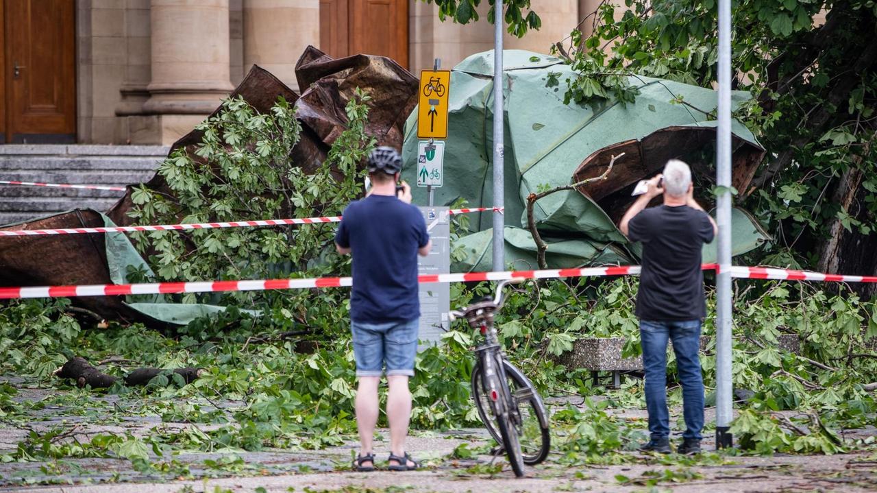 Zwei Männer fotografieren das vom Opernhaus gestürzte Dachteil. Zwei Männer fotografieren das vom Opernhaus gestürzte Dachteil.
