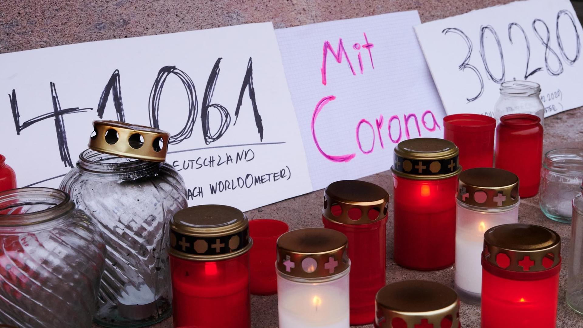 Mehrere Plakate, Grablichter und Kerzen stehen auf dem Podest des Stierbrunnens in Prenzlauer Berg und erinnern an die die aktuelle Zahl der Toten durch Corona in Deutschland. (Januar 2021) Mehrere Plakate, Grablichter und Kerzen stehen auf dem Podest des Stierbrunnens in Prenzlauer Berg und erinnern an die die aktuelle Zahl der Toten durch Corona in Deutschland. (Januar 2021)