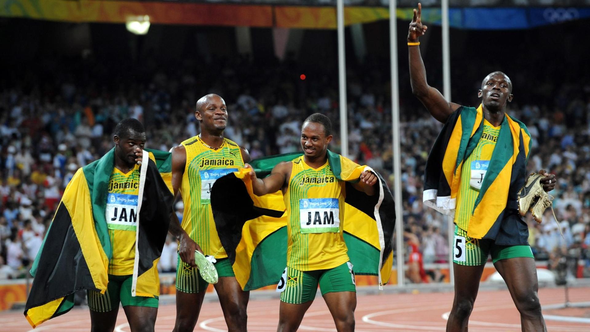 Olympia in Peking 2008 - die jamaikanische 4x100-Meter-Staffel mit Nesta Carter, Asafa Powell, Michael Frater und Usain Bolt nach dem Finallauf