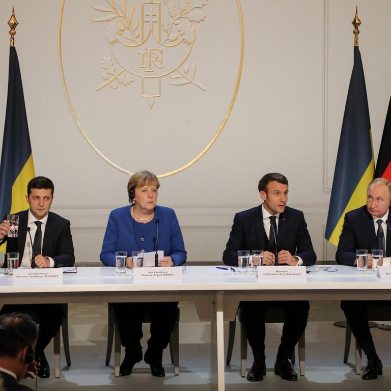 Der ukrainische Präsident Zelensky, Bundeskanzlerin Merkel, Frakreichs Staatschef Macron und der russische Präsident Putin bei einer Pressekonferenz im Elysee Palst